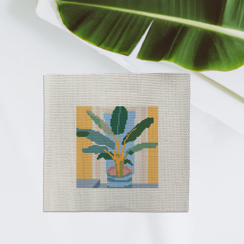 A needlepoint canvas with a banana leaf plant design on it